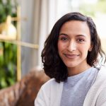 Young mixed race woman in coffee shop looking to camera